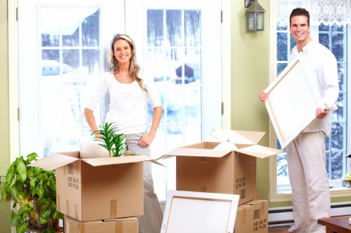Local removalists carrying furniture through a narrow Lambeth staircase